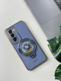 A blue silicone oppo reno 12 pro case with a decorative element on the back, placed on a table next to a laptop and a plant.